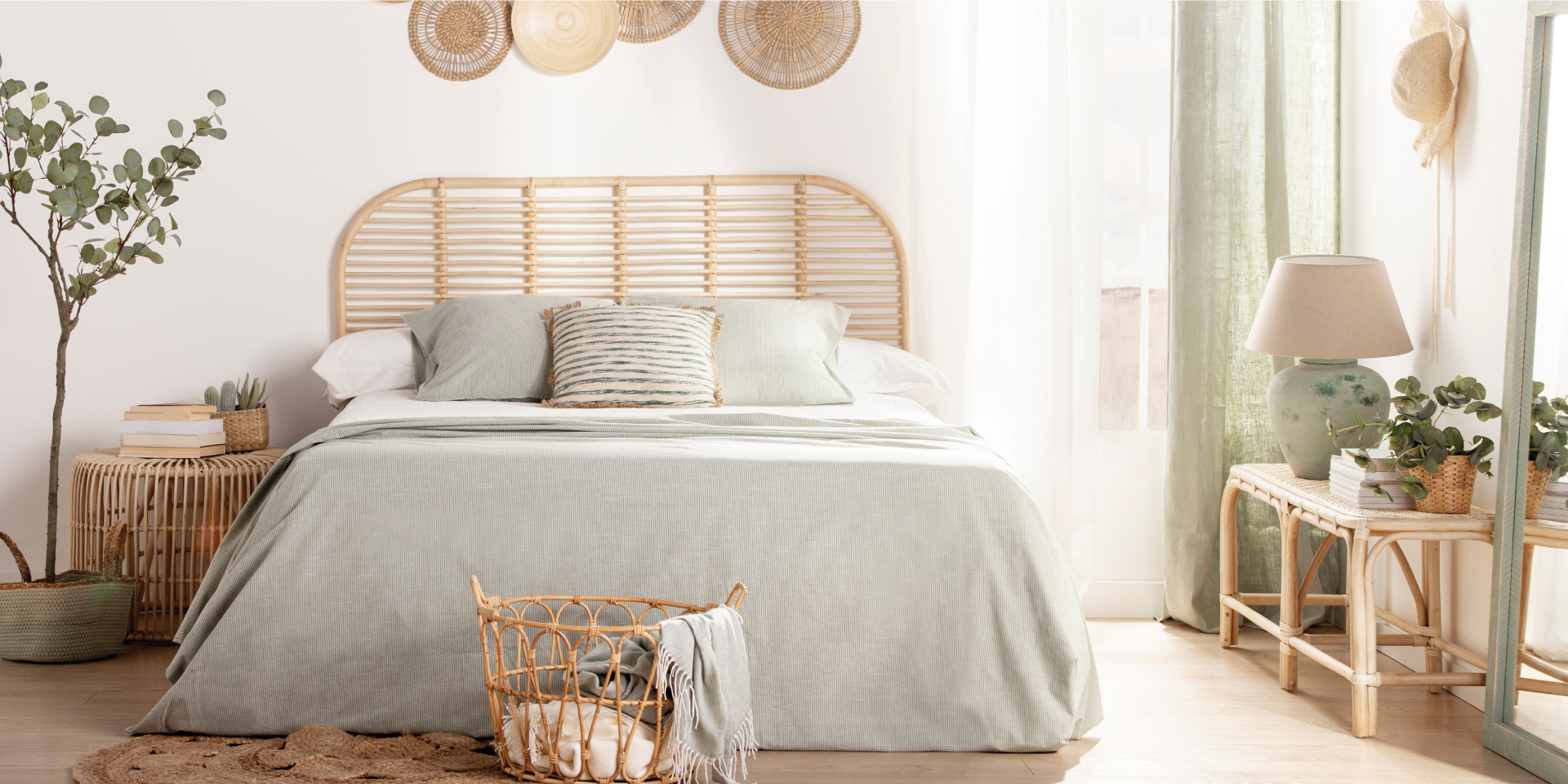 Composición elegante del interior del dormitorio con cama de madera,  muebles, decoración de alfombra, taburete, decoración de ratán, jarrones y  accesorios elegantes.